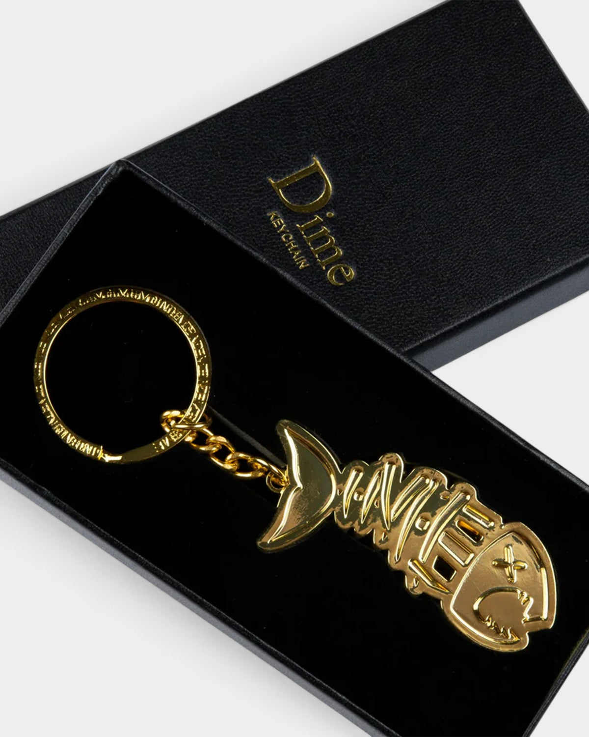 Lockwood Avenue Dime Bones keychain in gold-finished zinc alloy shaped like a fish skeleton inside a black gift box.