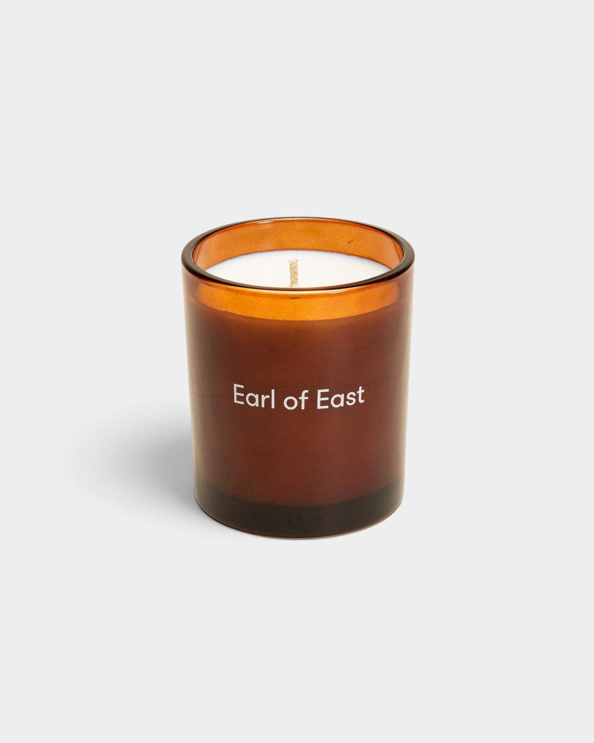 Lockwood Avenue Earl of East Smoke & Musk soy wax candle in a luxury amber glass vessel with white branding.
