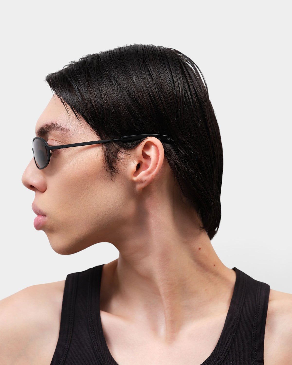 Lockwood Avenue Flatlist Cohen sunglasses in solid black worn by a model in profile view against a white background.