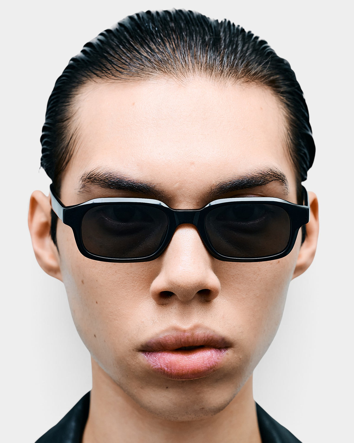 Lockwood Avenue Flatlist Hanky slim rectangular black acetate sunglasses worn by a man in a front-facing portrait