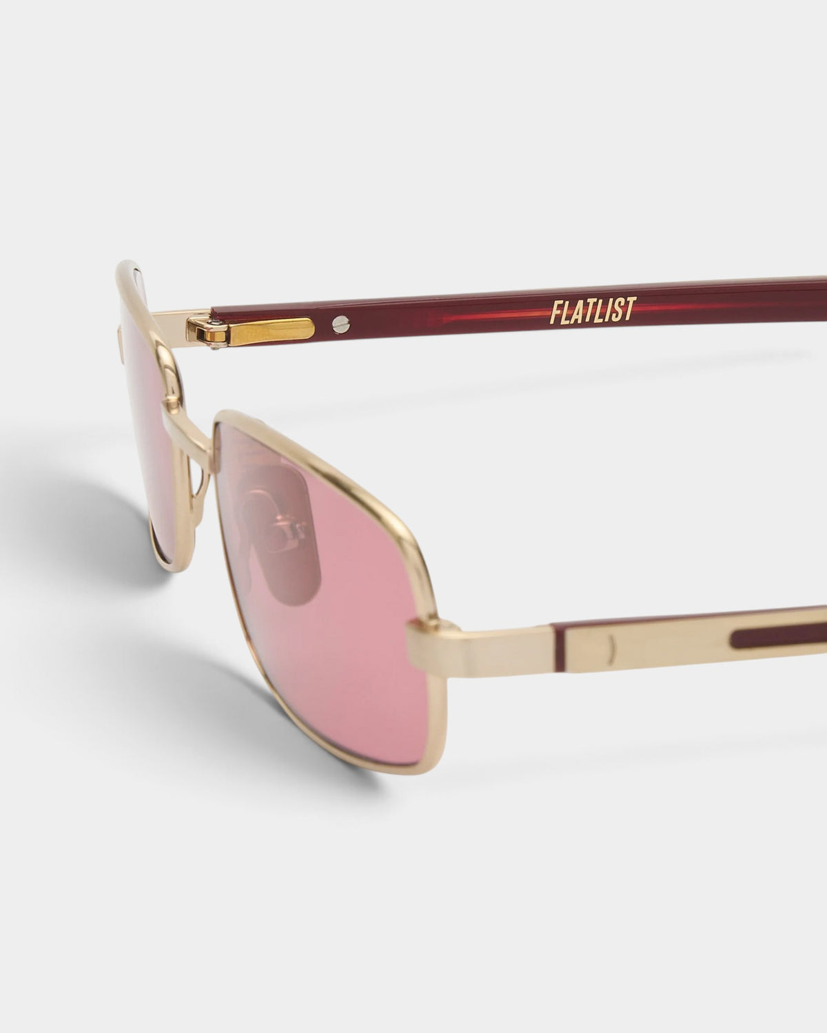 Lockwood Avenue Flatlist Sting sunglasses featuring a brushed light gold titanium frame and pink Carl Zeiss lenses.