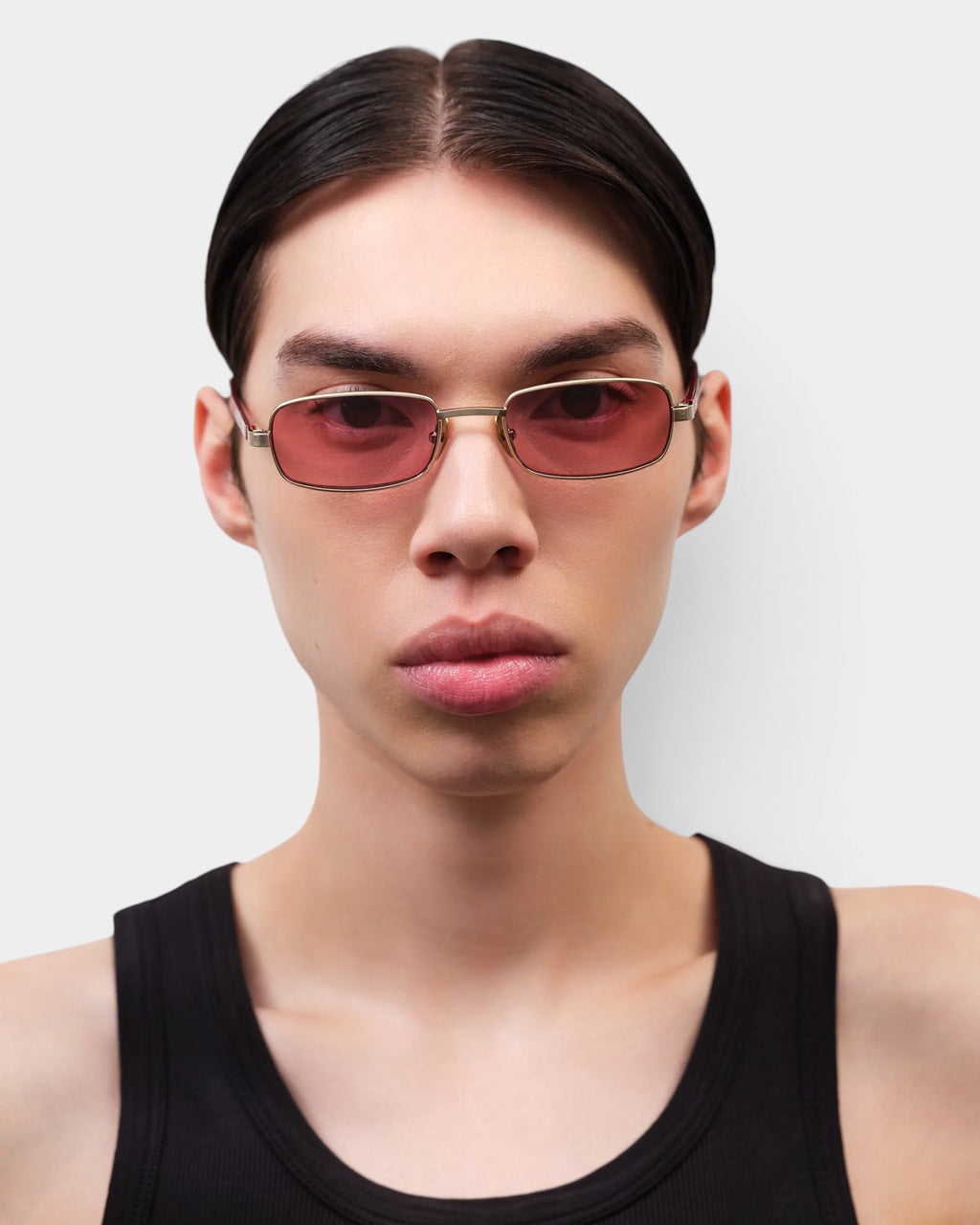Lockwood Avenue Flatlist Sting sunglasses with brushed light gold titanium frames and pink lenses on a model