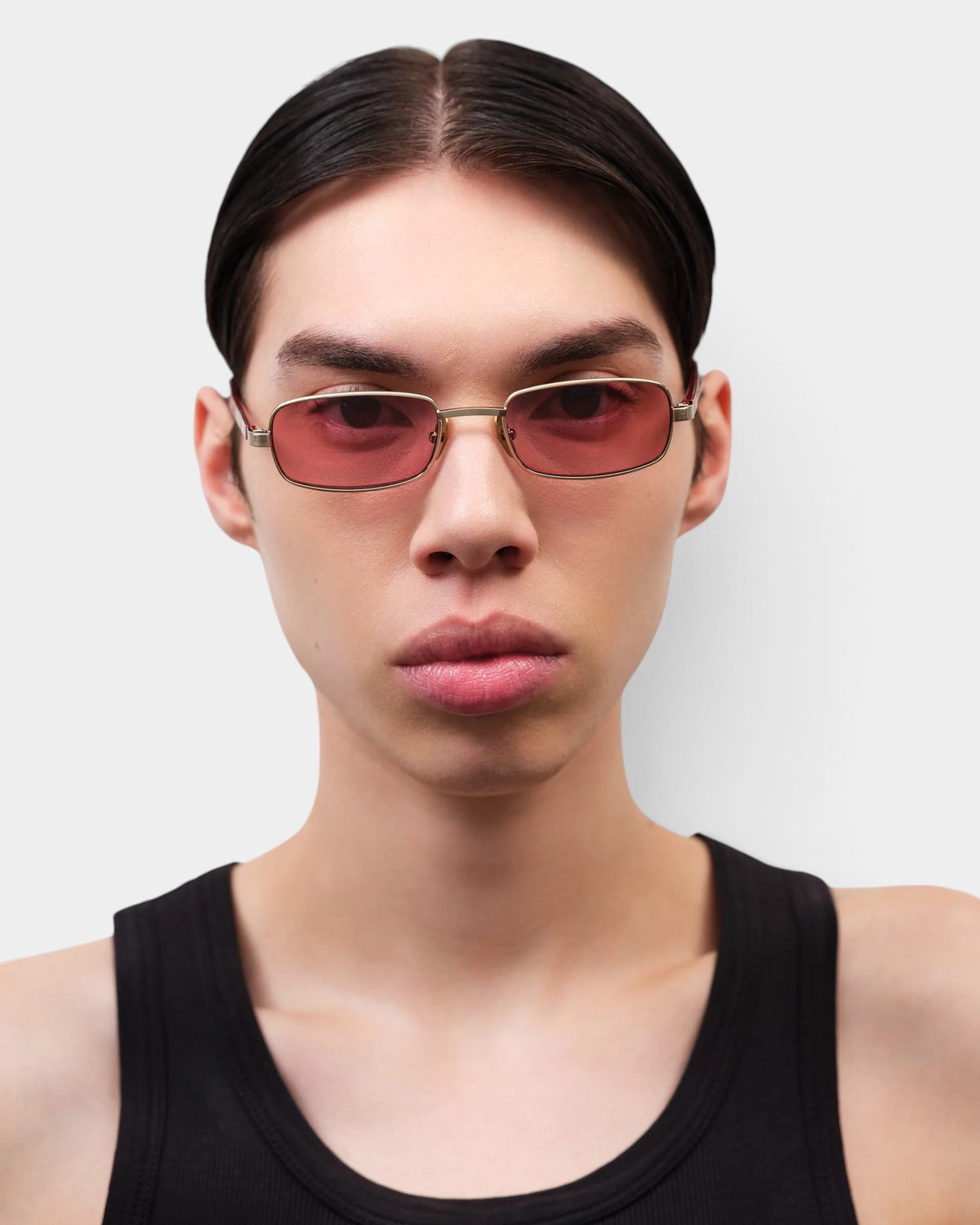 Lockwood Avenue Flatlist Sting sunglasses with brushed light gold titanium frames and pink lenses on a model