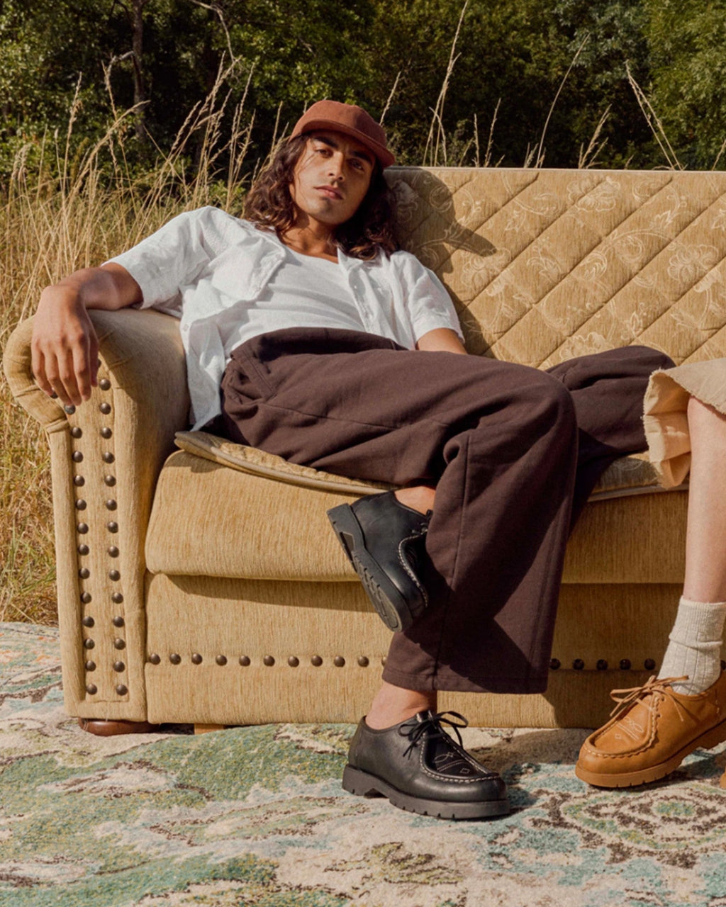 Lockwood Avenue model wearing black Kleman Padror FLK leather derby shoes with western stitching on a vintage sofa