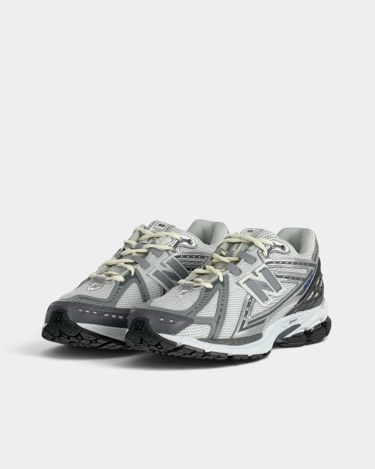 Lockwood Avenue New Balance 1906R performance running shoes in grey and silver with mesh upper and metallic overlays.