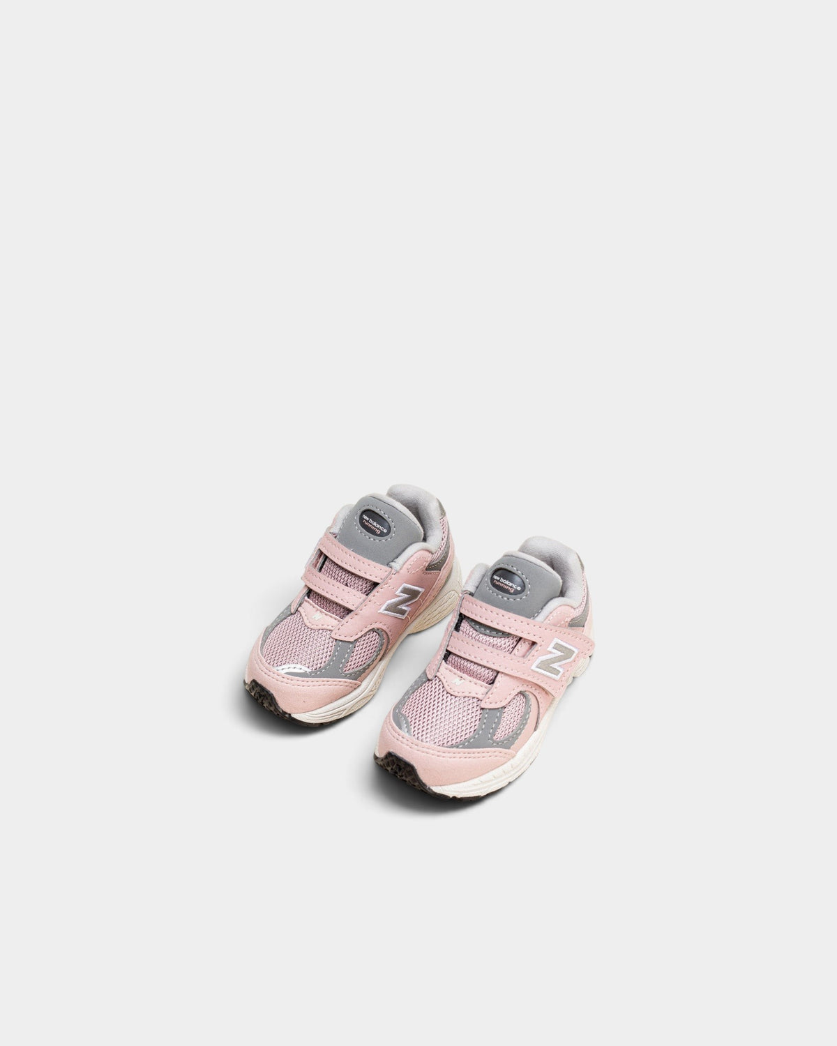 Lockwood Avenue New Balance 2002R toddler shoes in orb pink and shadow grey with mesh, suede, and hook-and-loop strap.
