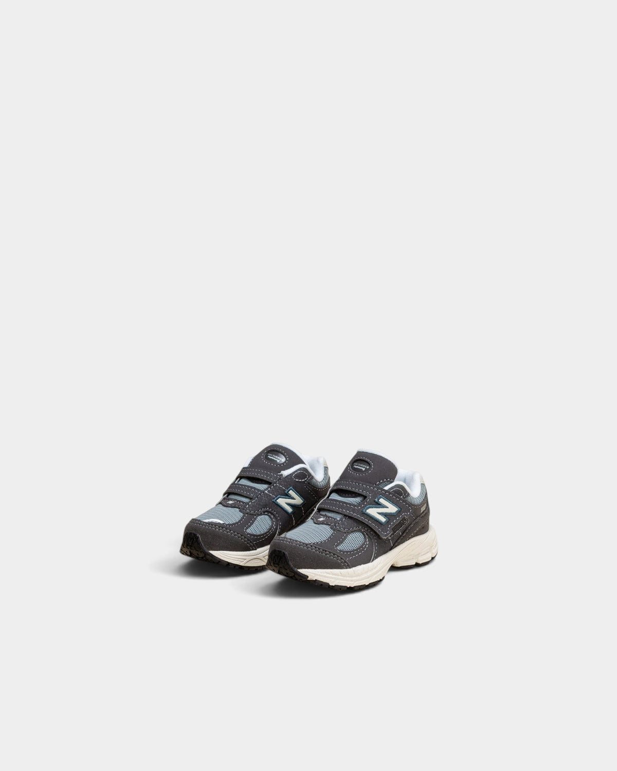 Lockwood Avenue New Balance 2002R toddler shoes in magnet and lead gray with mesh, suede, and hook-and-loop straps.