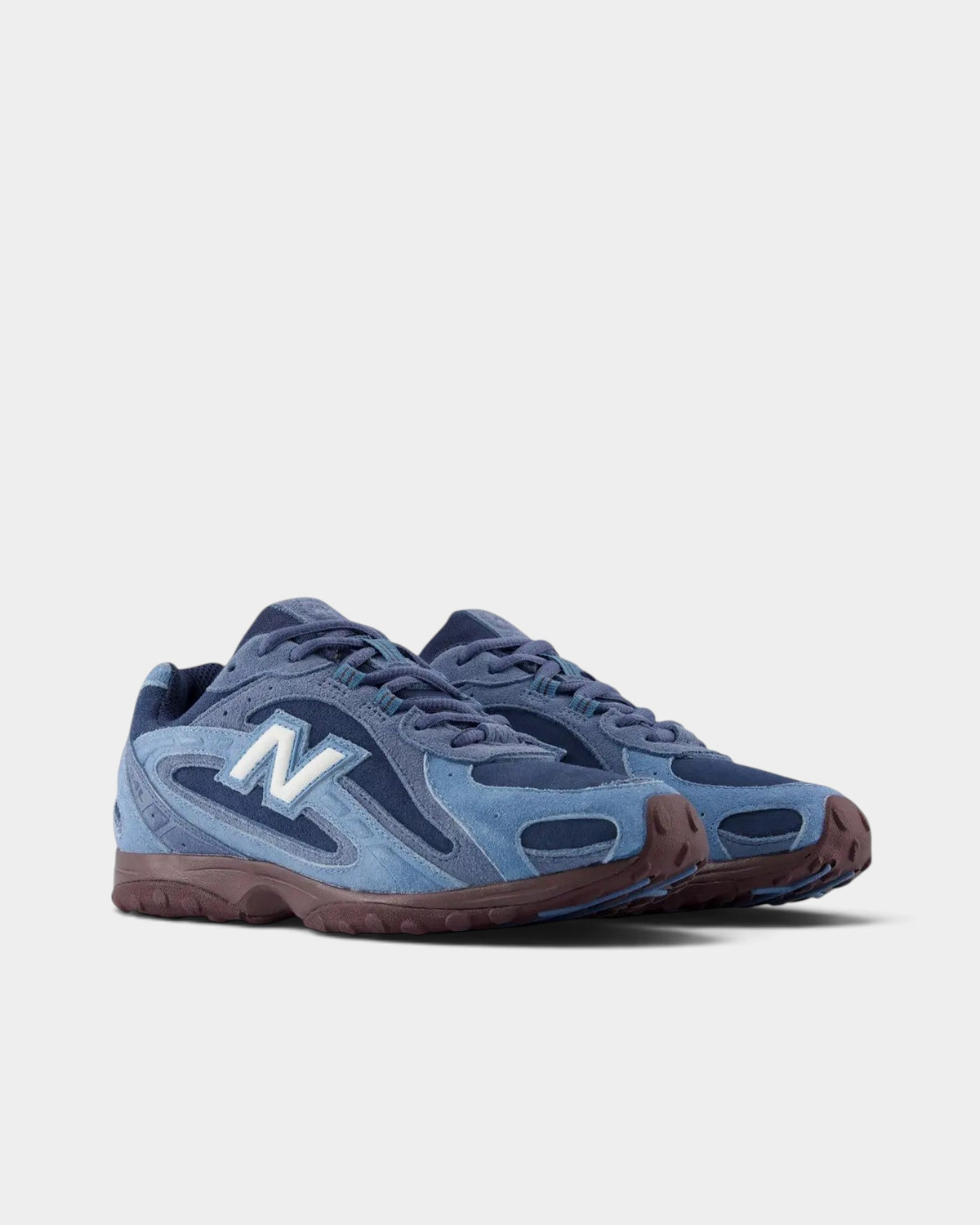 Lockwood Avenue New Balance 204 sneakers in blue suede and mesh with a plum-brown outsole and white N logo.