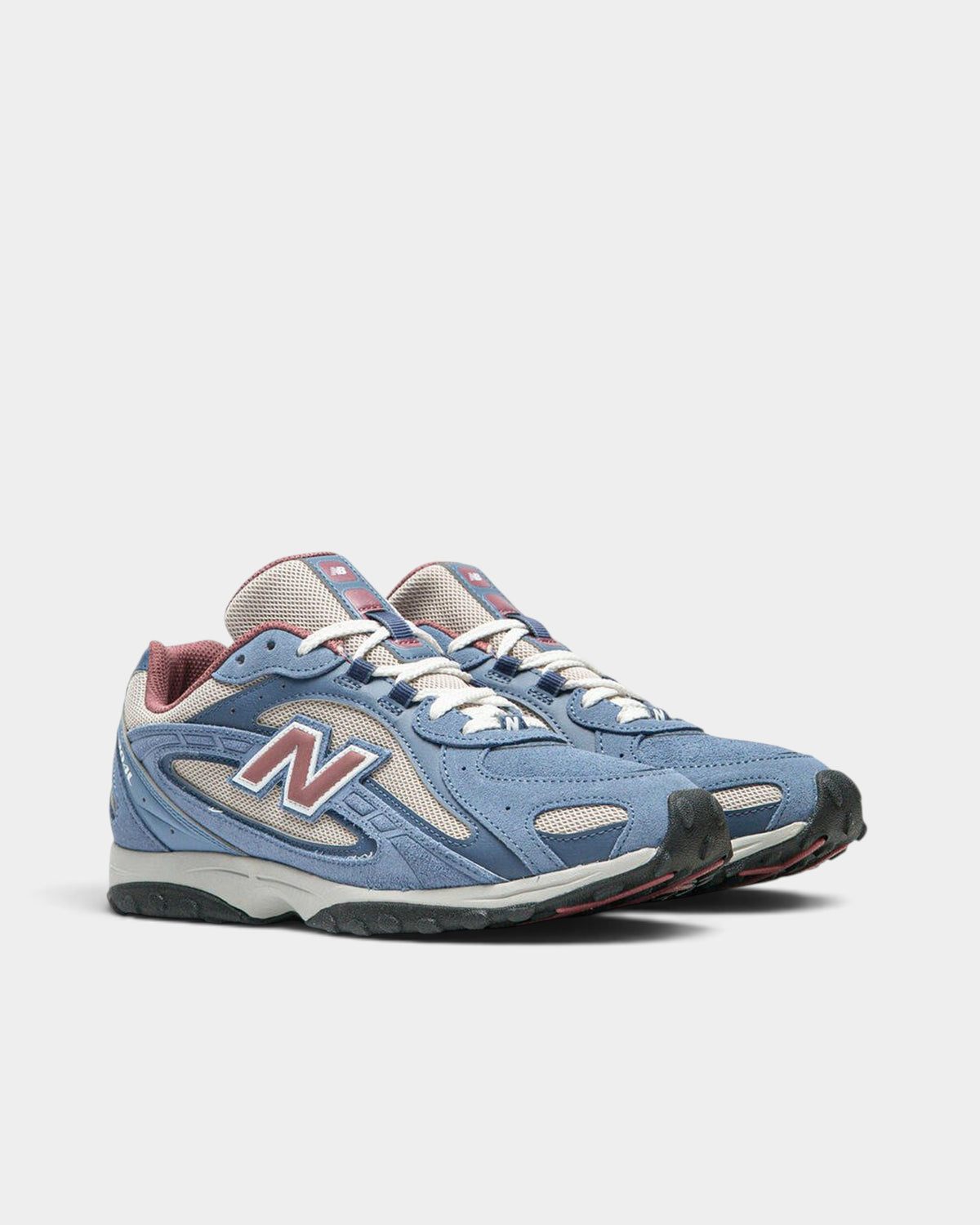 Lockwood Avenue New Balance 204L lifestyle runner in blue suede and off-white mesh with clay red logo accents.