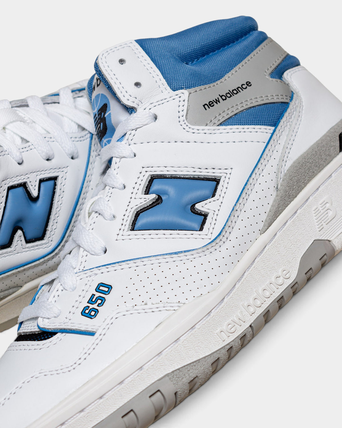 Lockwood Avenue New Balance 650 high-top sneakers in white leather with heritage blue accents and gray trim details.