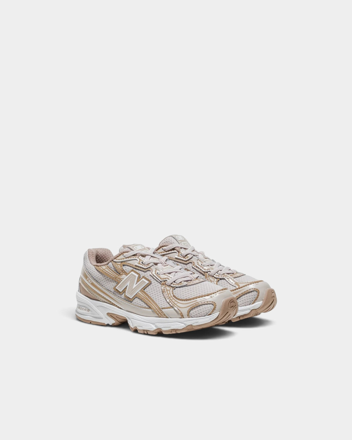 Lockwood Avenue New Balance 740 kids sneakers in beige mesh with metallic gold overlays and bungee lacing.