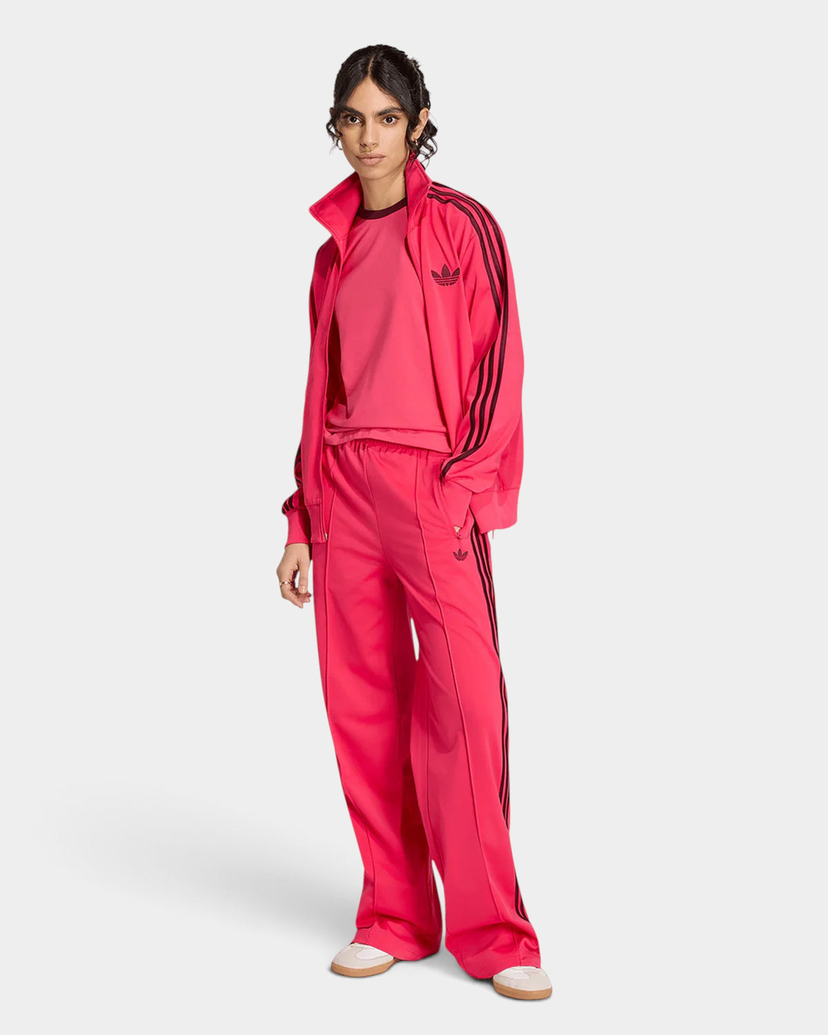 Lockwood Avenue model wearing pink adidas Adicolor Classic Firebird loose track pants with maroon 3-Stripes.