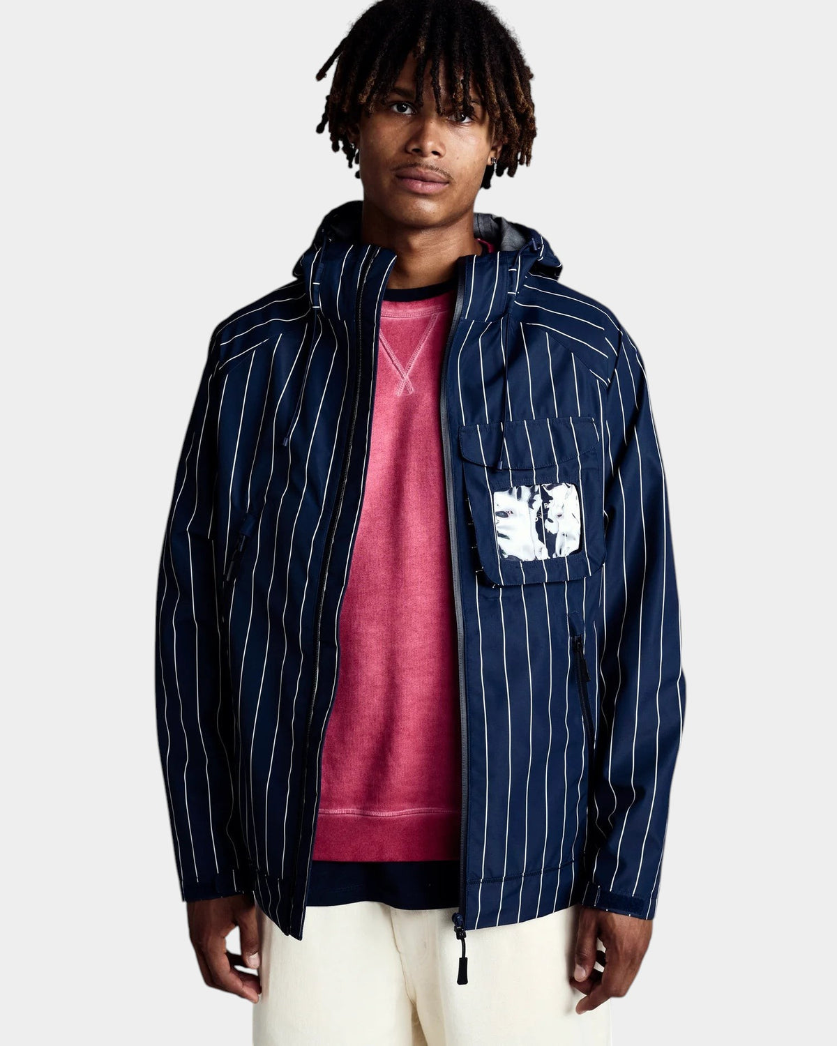 Lockwood Avenue model wearing a navy blue pinstripe waterproof polyester ripstop Oracle jacket with window pocket.