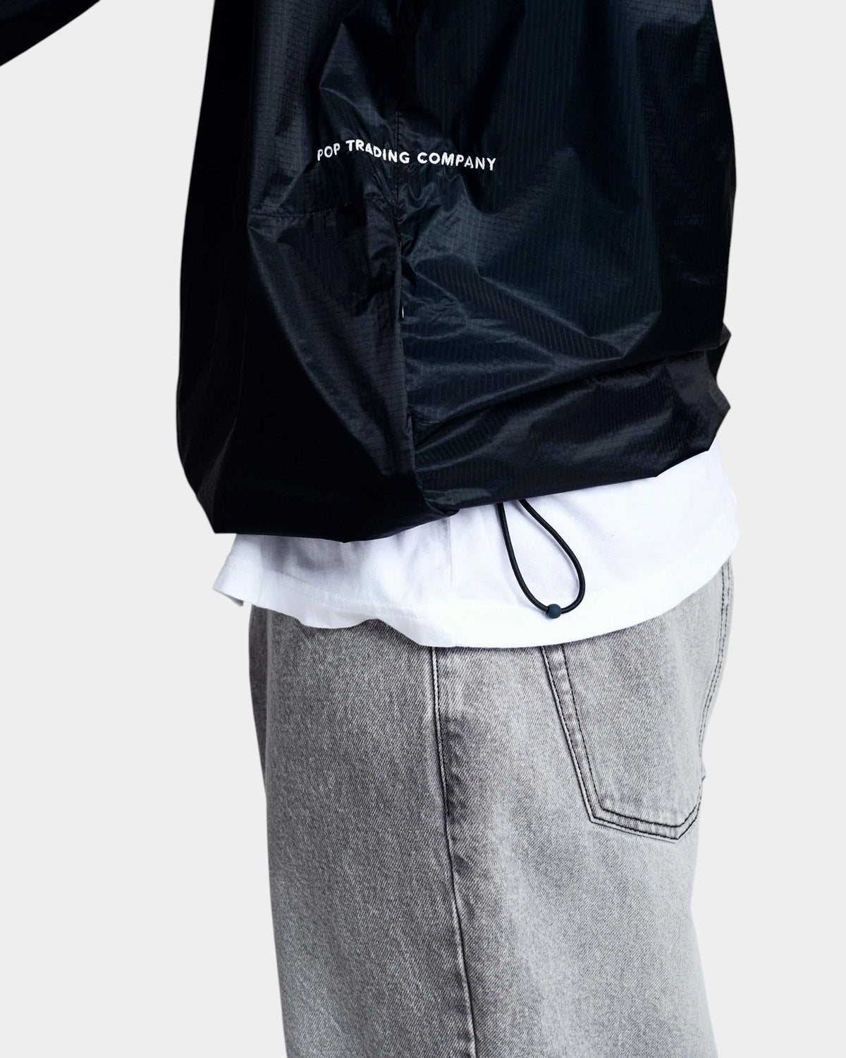 Lockwood Avenue Pop Trading Company black nylon team jacket with elasticated hem and cord lock detail