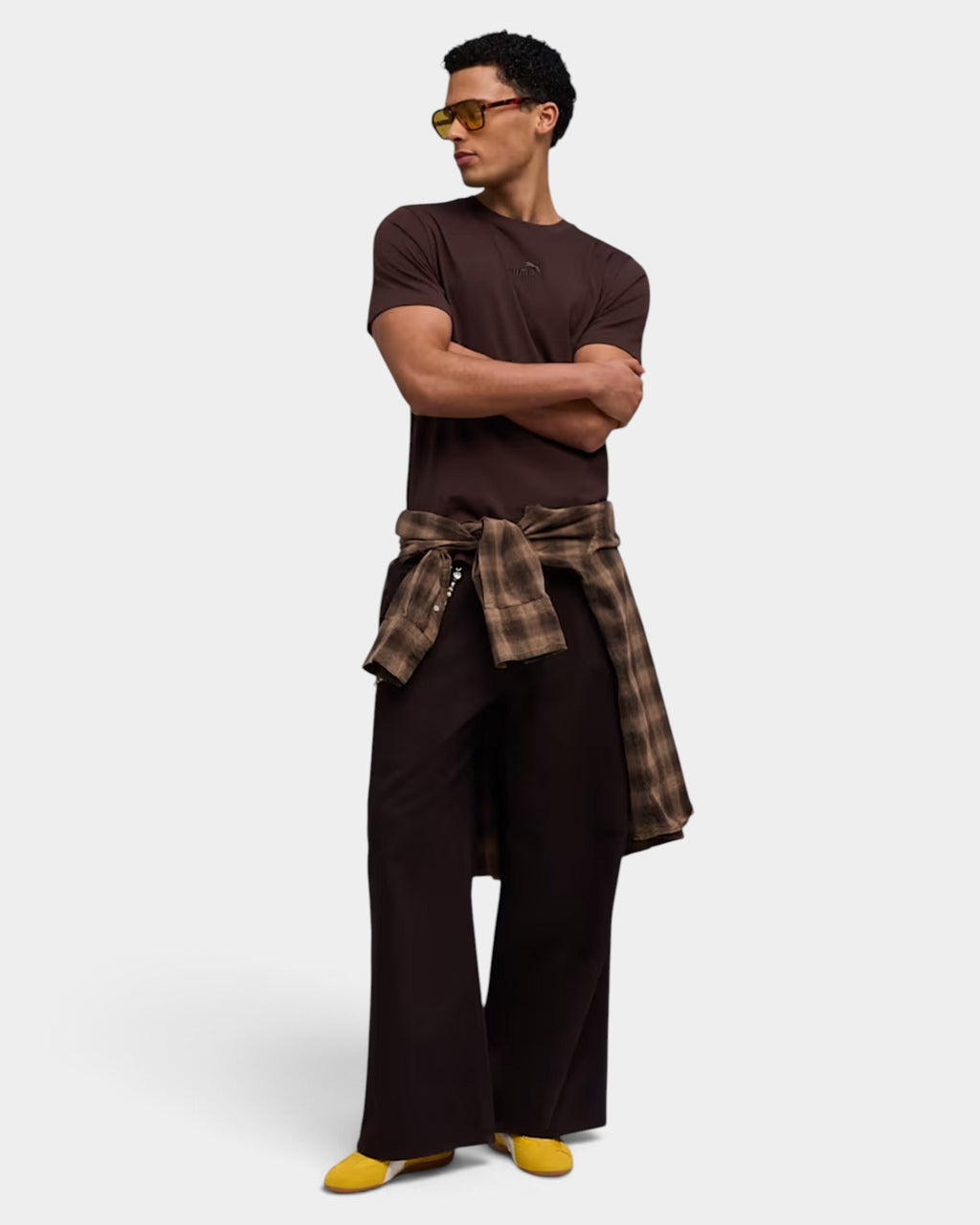 Lockwood Avenue model wearing yellow Puma Speedcat nylon shoes with a brown t-shirt and plaid shirt tied at waist