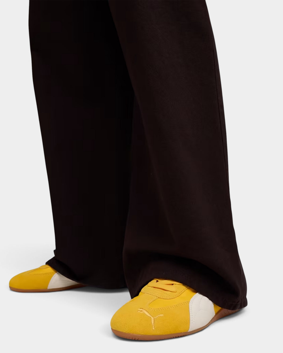 Lockwood Avenue Puma Speedcat nylon sneakers in Yellow Sizzle with white Formstrip worn with dark wide-leg trousers