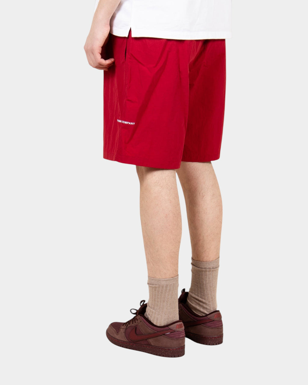 Lockwood Avenue red nylon painter shorts with white logo, loose fit, and side pocket, worn by a model.