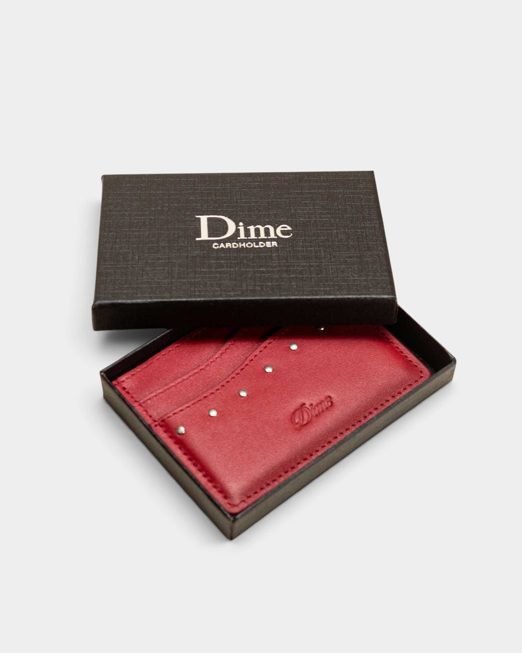 Lockwood Avenue Dime red leather cardholder with metal studs and embossed logo in a black presentation box