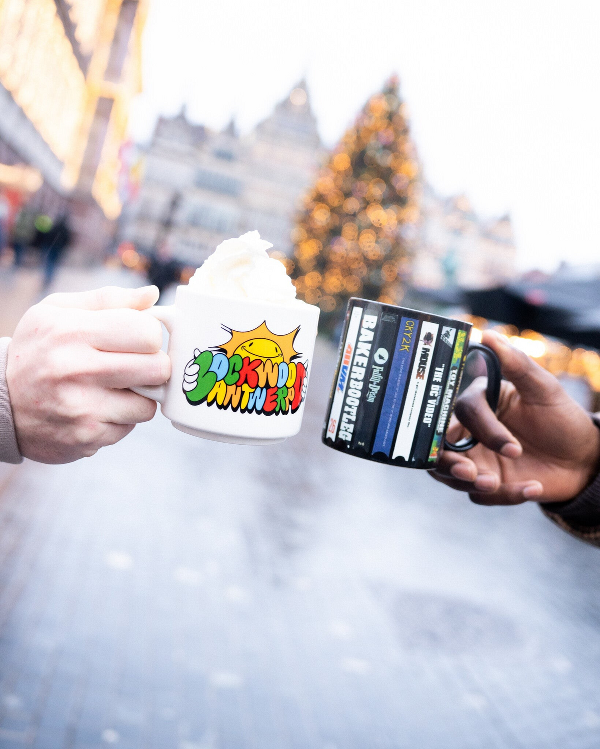 Lockwood Avenue Sunny Antwerp ceramic stacking mug with colorful sun graphic held outdoors in a festive setting.