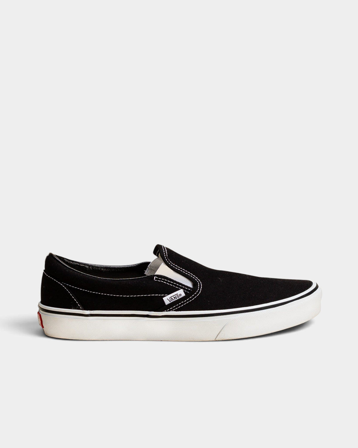 Lockwood Avenue Vans Classic Slip-On shoes in black canvas with a white rubber sole and side elastic gores.