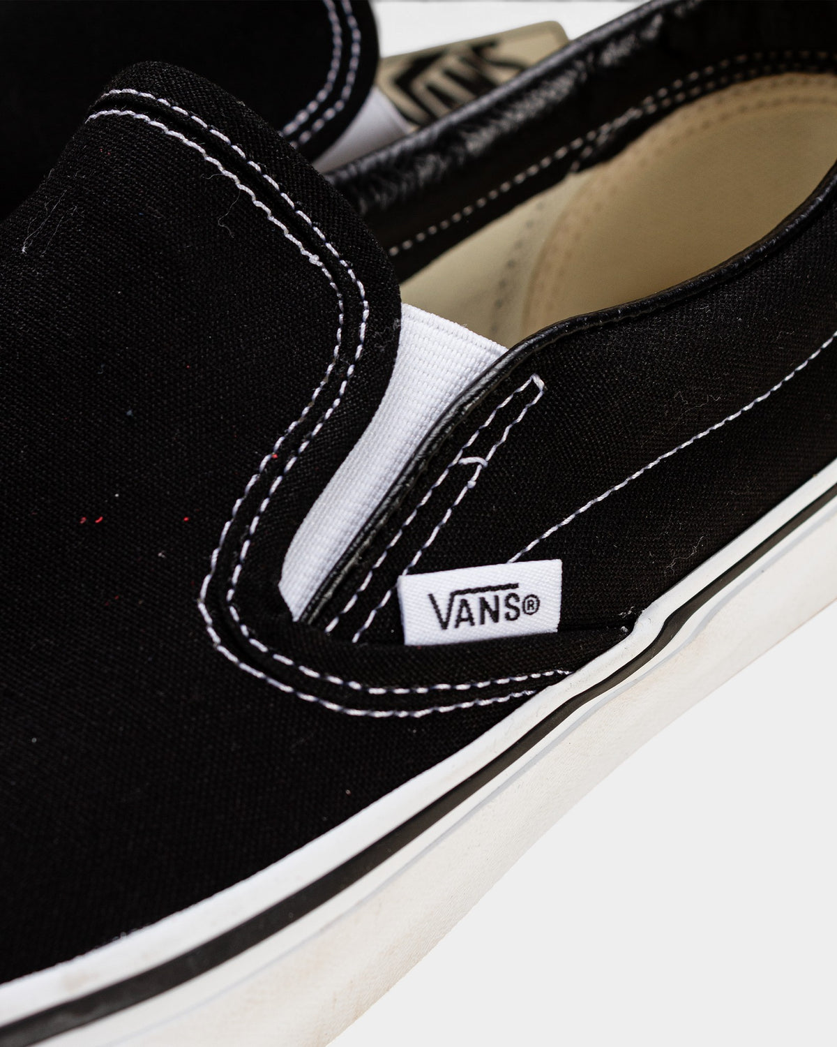 Lockwood Avenue Vans Classic Slip-On black canvas shoe with white stitching and side gore detail