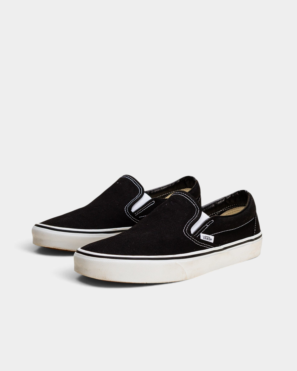 Lockwood Avenue Vans Classic black canvas slip-on shoes with white rubber soles and elastic side gores