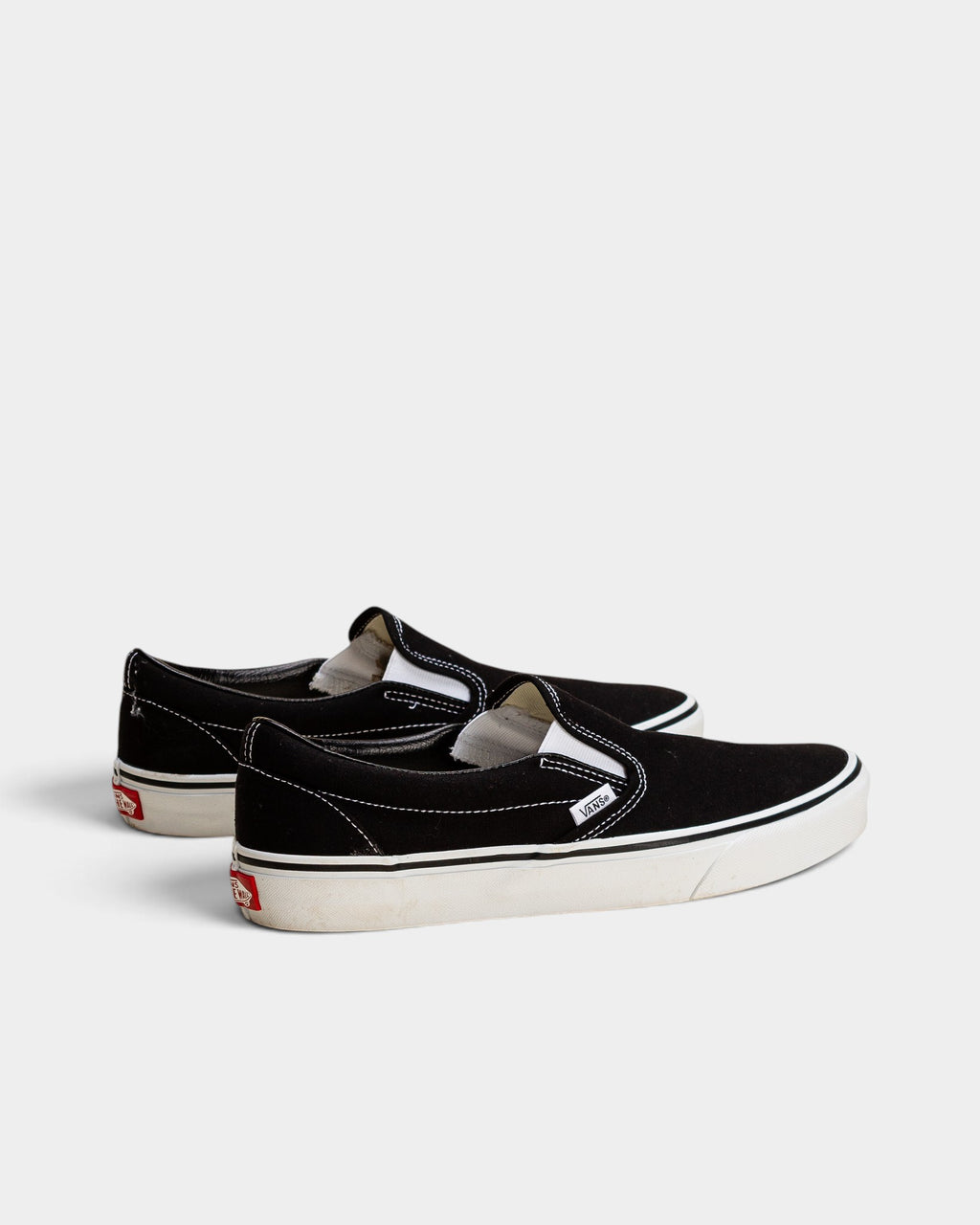 Lockwood Avenue Vans Classic Slip-On shoes in black canvas with white rubber soles and signature waffle outsoles.