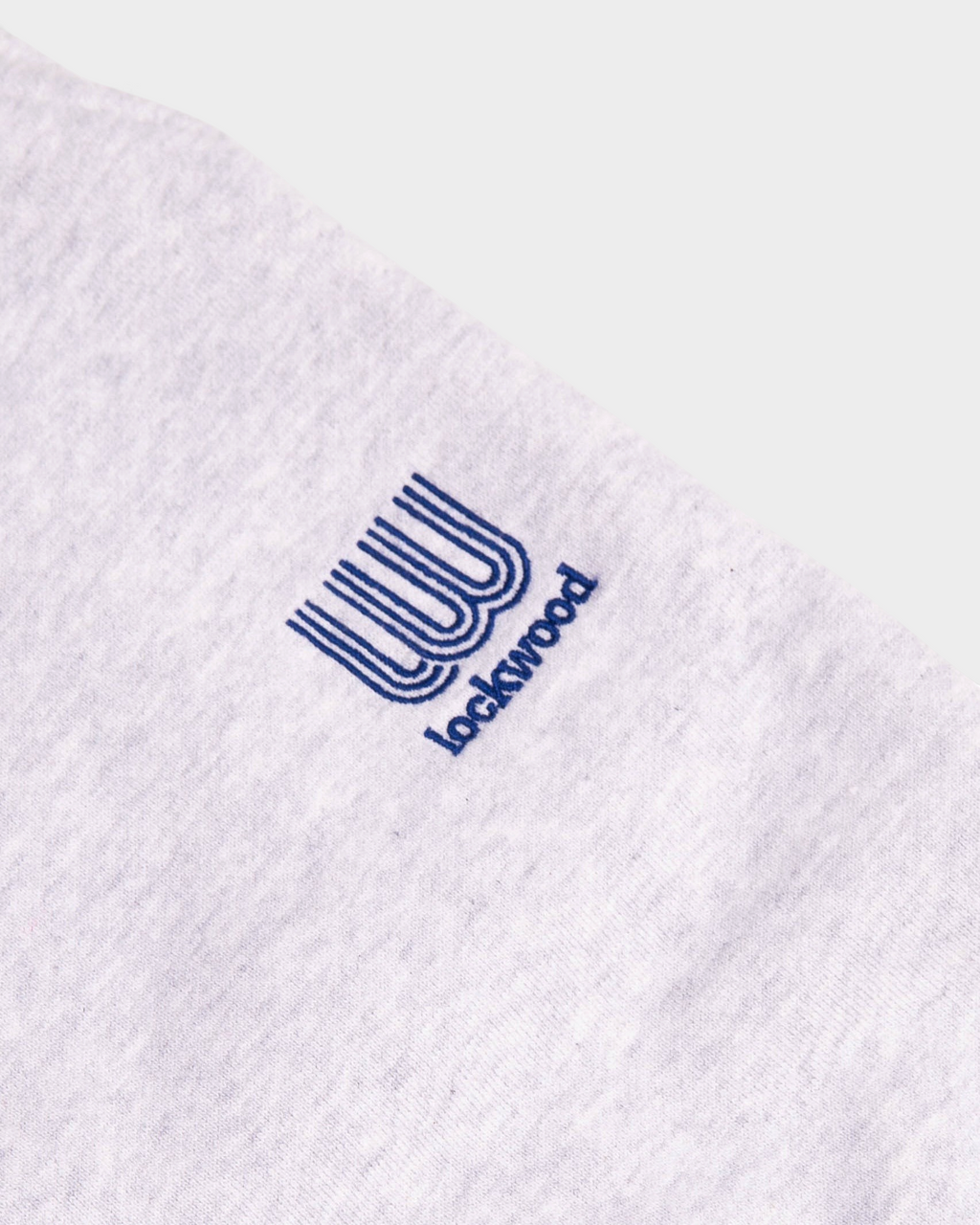Close-up of the small blue embroidered Lockwood logo on the heather grey Lockwood Small Embroidered Logo Sweatpants