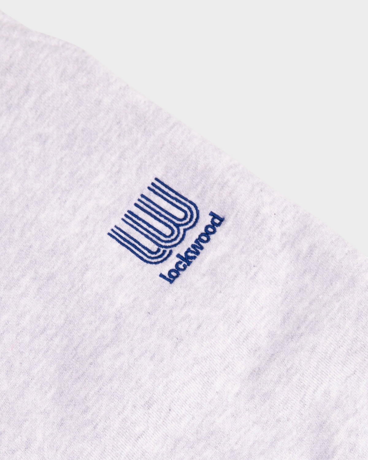 Close-up of the small blue embroidered Lockwood logo on the heather grey Lockwood Small Embroidered Logo Sweatpants