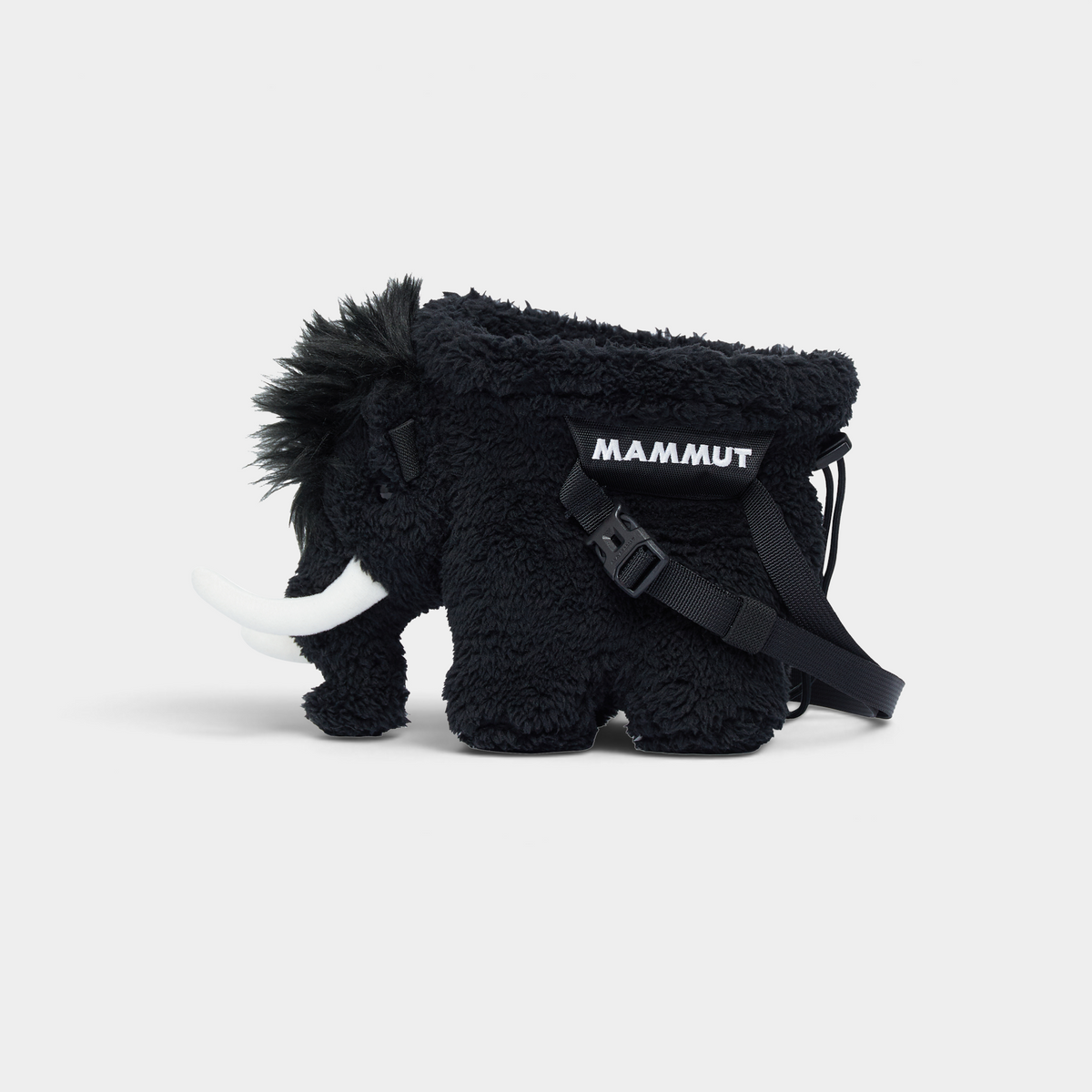 Mammut Fluffy Chalk Bag in black, a fleecy mammoth-shaped climbing chalk bag seen side on, with white tusks and a black MAMMUT webbing belt across its flank