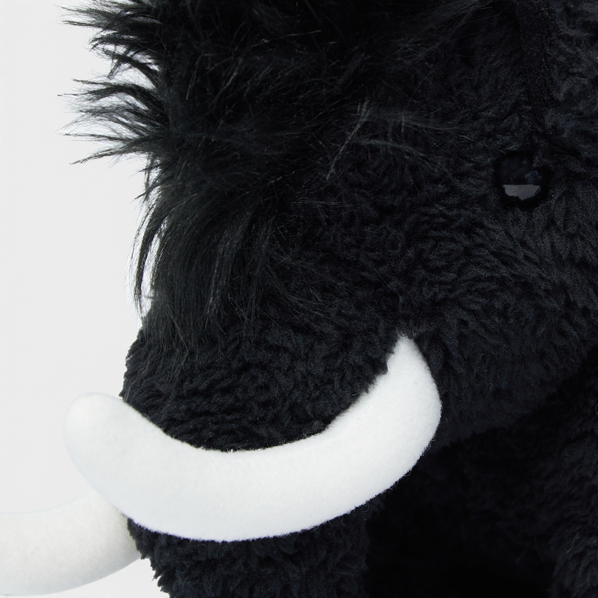 Close-up of the Mammut Fluffy Chalk Bag's head, showing the black fleece pile, the shaggy mane and the white tusks