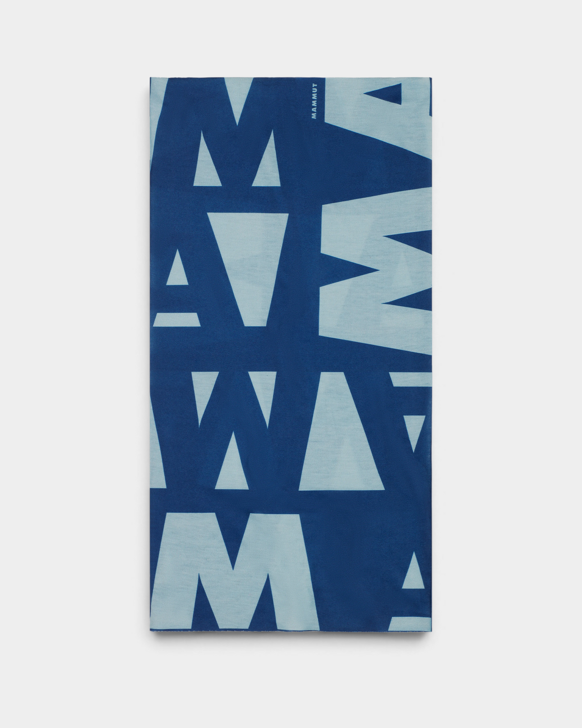 Mammut Logo Neck Gaiter in Tschiel-Nebla, a tube neck gaiter laid flat, printed with the MAMMUT wordmark repeated oversized in pale ice blue on mid blue