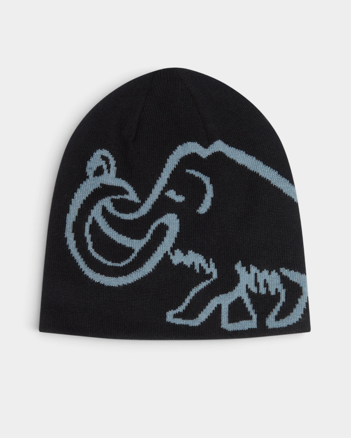 Mammut Logo Reversible Beanie in Black-Strata, a black cuffless beanie with a large pale grey-blue knitted mammoth across the side