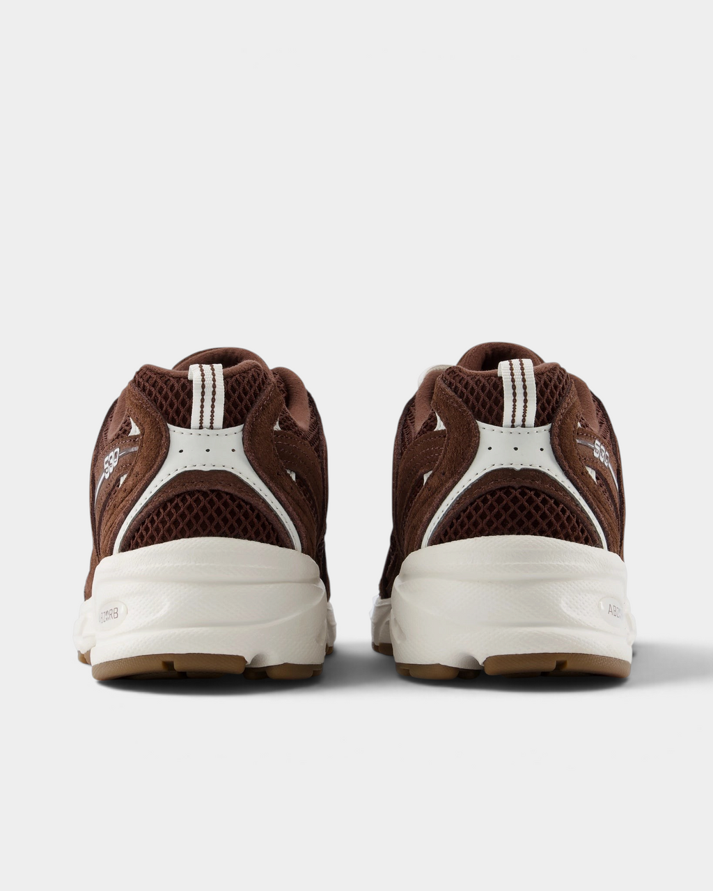 New Balance 530 Shoes in Pumpernickel/Sea Salt, pair from behind: brown heel panels with white heel tabs over a white midsole and gum outsole