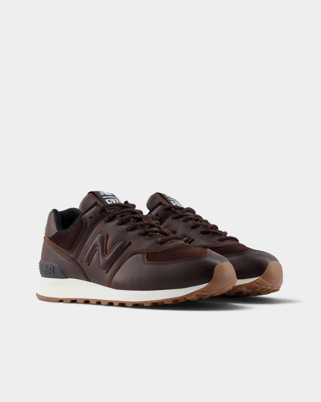 New Balance 574 Shoes in Pumpernickel/Sea Salt, pair at a three-quarter front angle showing the brown leather toe cap, tonal N logos and brown laces