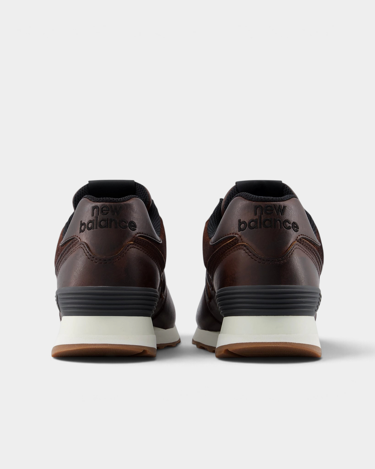 New Balance 574 Shoes in Pumpernickel/Sea Salt, pair from behind: brown leather heels with a dark grey heel counter over a cream midsole