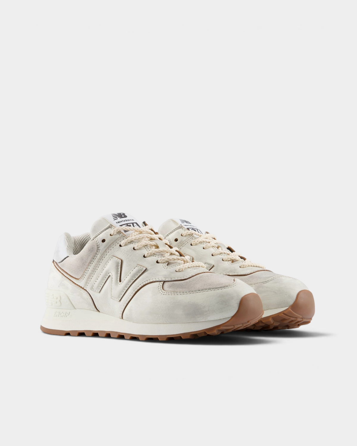 New Balance 574 Shoes in Sea Salt/Breakfast Tea, pair at a three-quarter front angle showing the cream toe cap, tonal N logos and cream laces