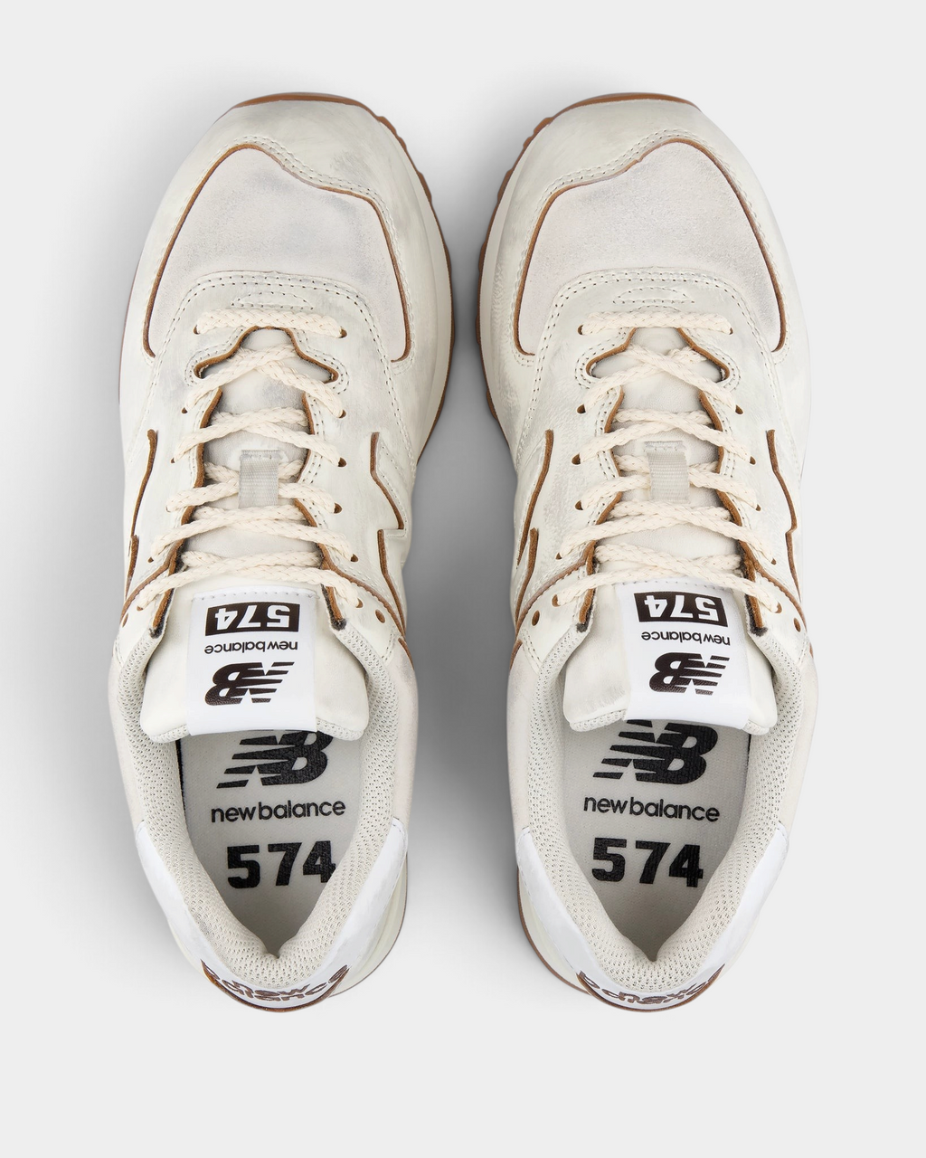 New Balance 574 Shoes in Sea Salt/Breakfast Tea, pair from above with cream laces, white 574 tongue labels and tan piping around the collar