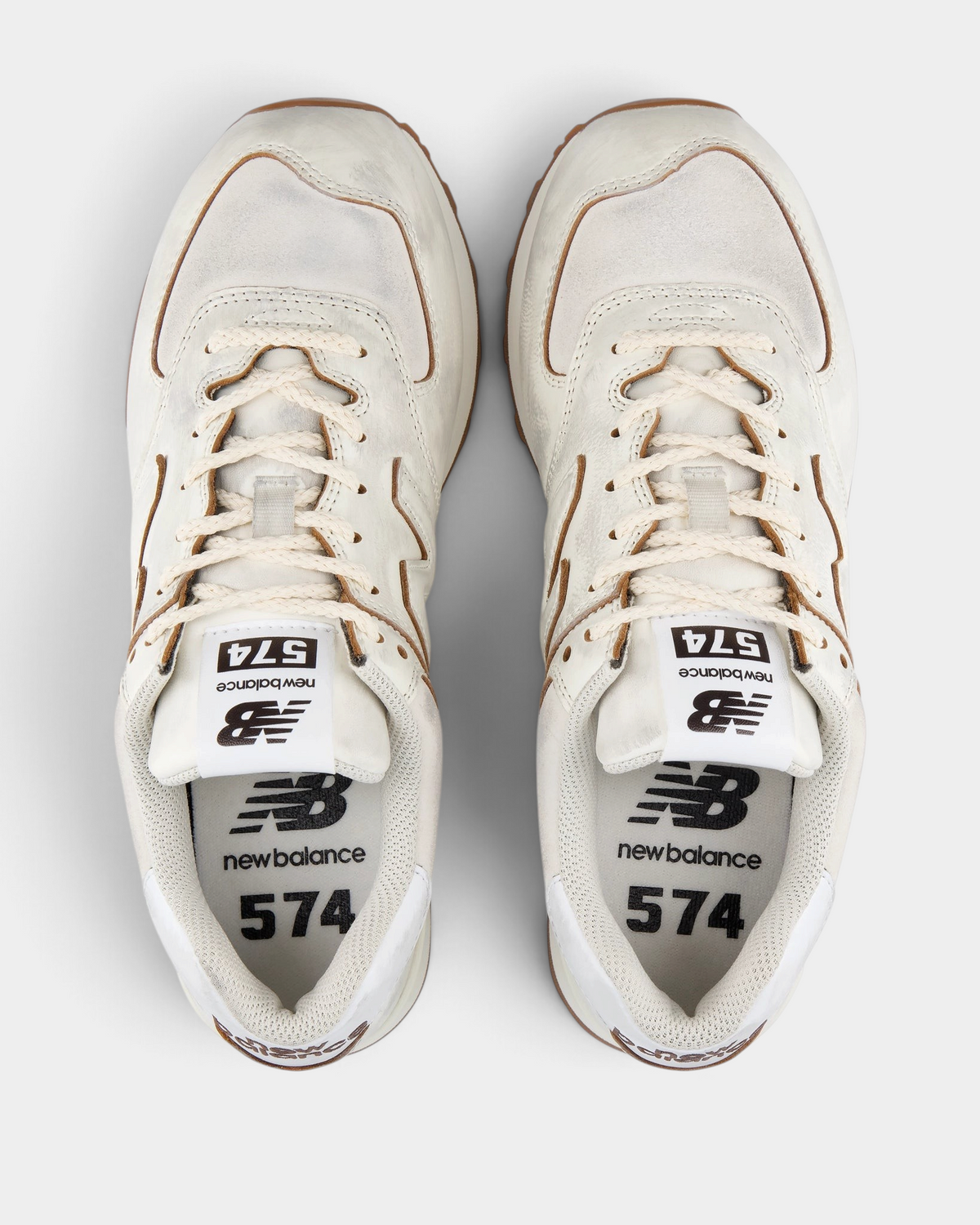 New Balance 574 Shoes in Sea Salt/Breakfast Tea, pair from above with cream laces, white 574 tongue labels and tan piping around the collar