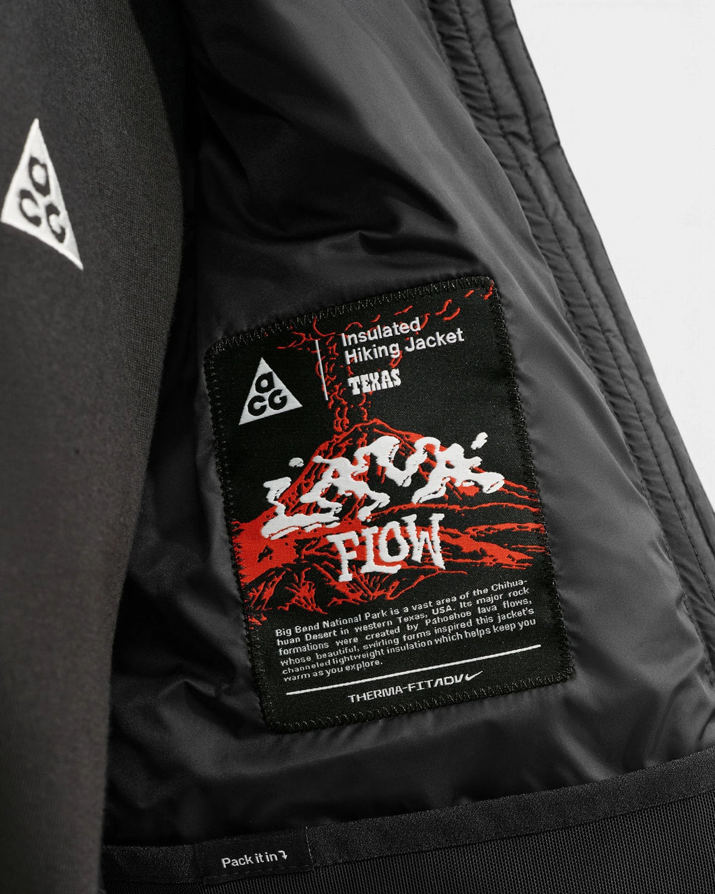 Inside of the Nike ACG Lava Flow Women's Jacket in black and summit white, showing the woven Lava Flow Insulated Hiking Jacket label and the Therma-FIT ADV tag