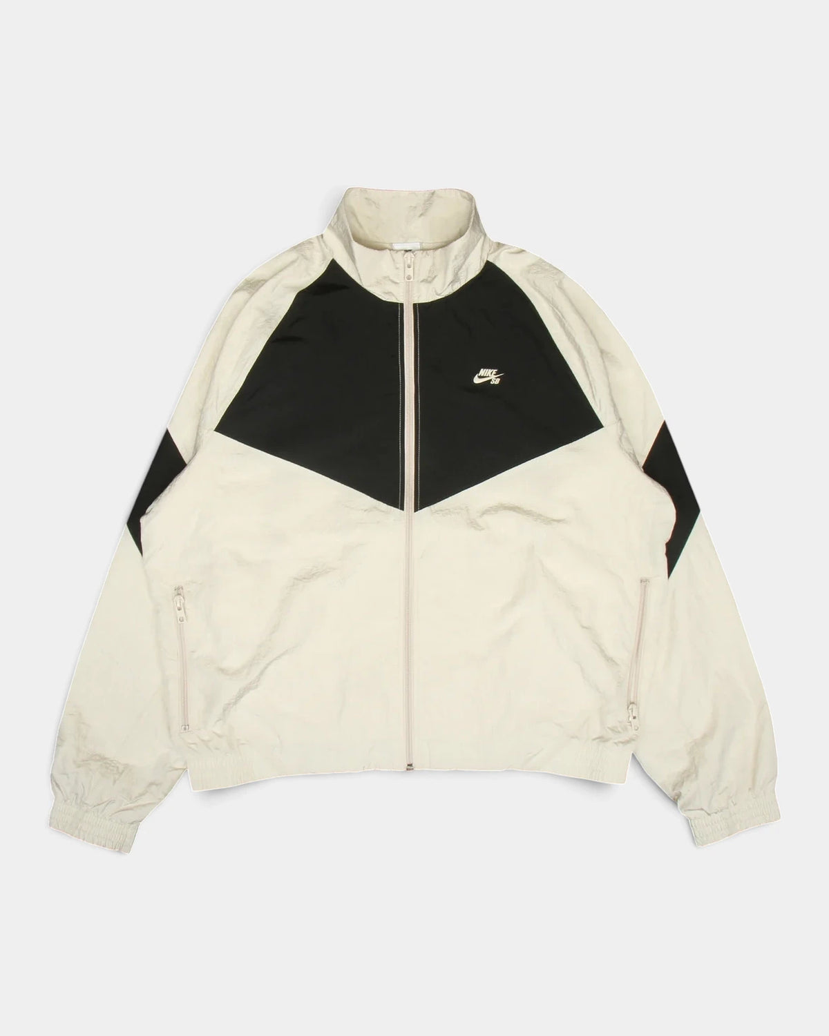 Nike SB Pavan Jacket in light orewood brown and black, flat-lay front view with the black chevron panel across the chest and the Nike SB logo