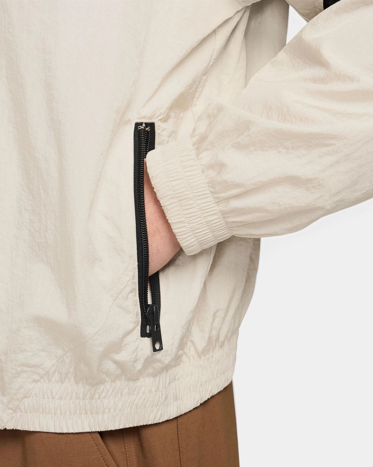 Detail of the zip pocket and elastic cuff on the Nike SB Pavan Jacket in light orewood brown