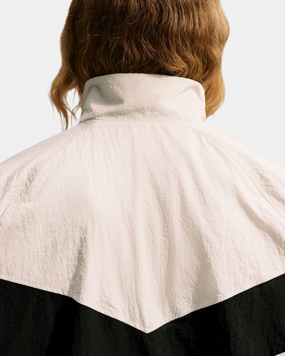 Back detail of the Nike SB Pavan Jacket's stand collar and black chevron panel in crinkled nylon taffeta