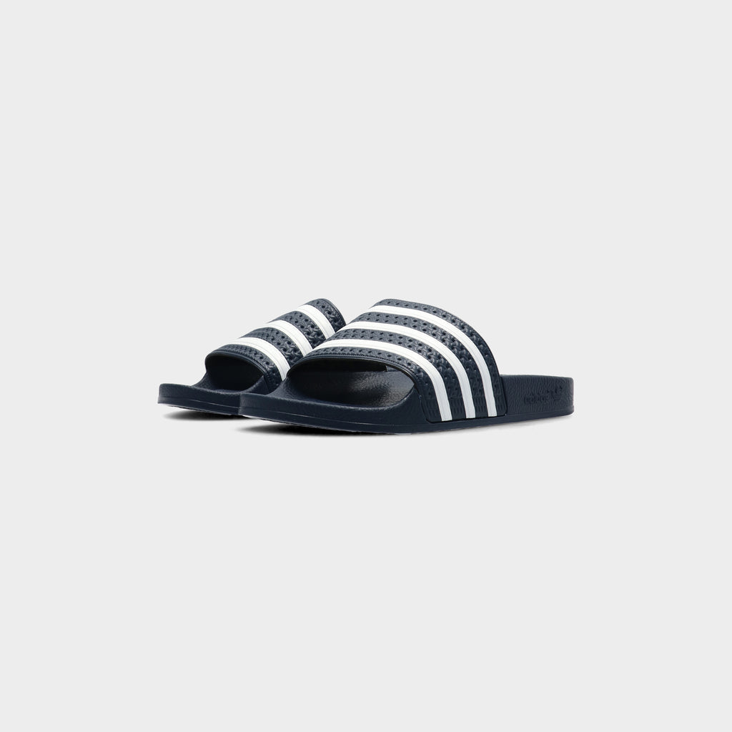 Lockwood Avenue pair of adidas Adilette Slides in AdiBlu navy with white 3-Stripes, angled front view