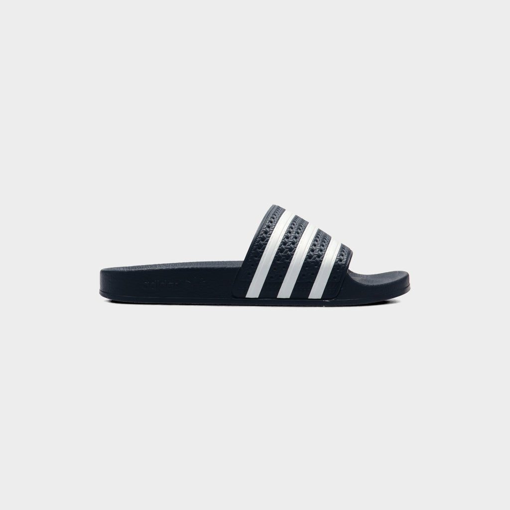 Lockwood Avenue adidas Adilette Slide in AdiBlu navy with white 3-Stripes across the strap, side view
