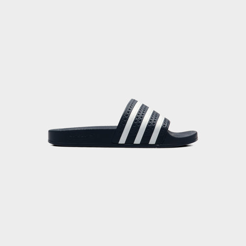 Lockwood Avenue adidas Adilette Slide in AdiBlu navy with white 3-Stripes across the strap, side view