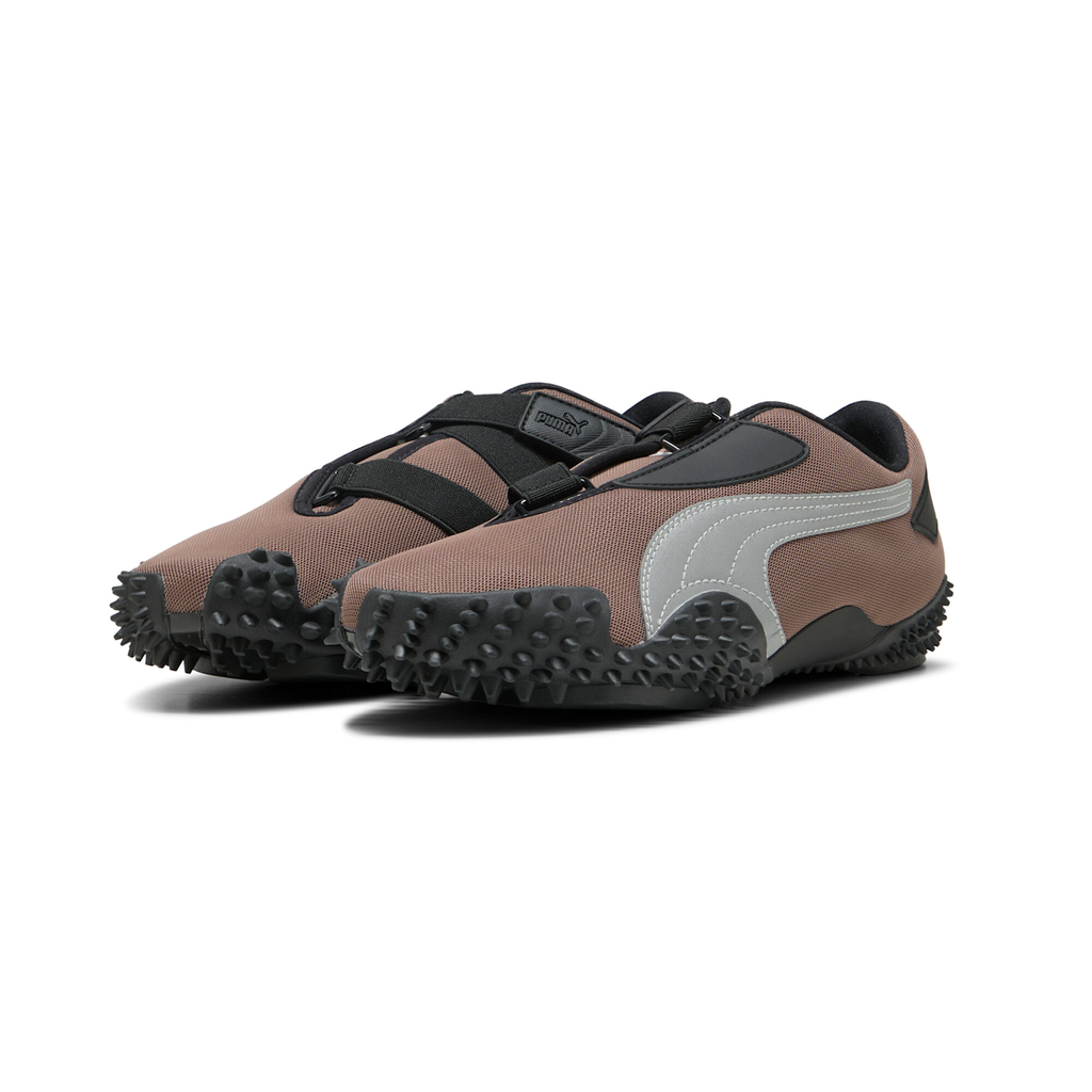Puma Mostro OG in Dark Clove and Puma Silver, three-quarter view of the pair showing the muted brown mesh upper, silver formstrip, black hook-and-loop straps and the spiked black rubber outsole