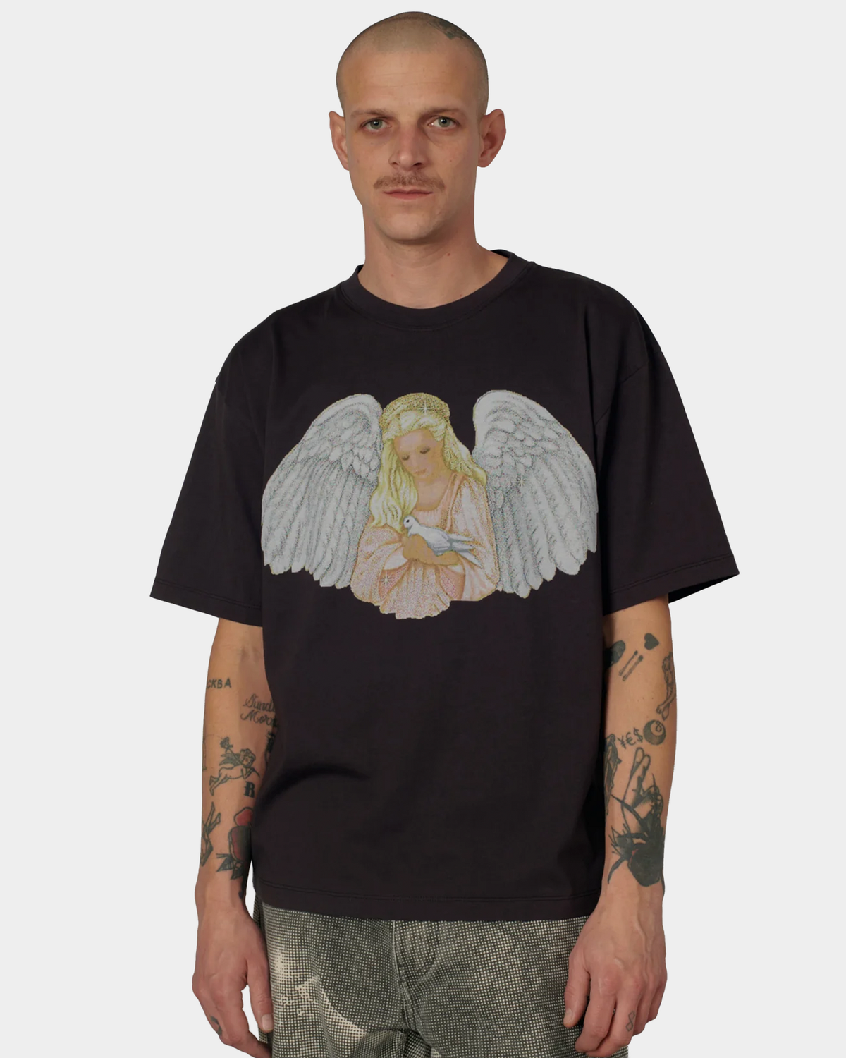 A man wearing the brown Rassvet Blessings T-Shirt with the angel print at the chest, shown from the front with camouflage trousers