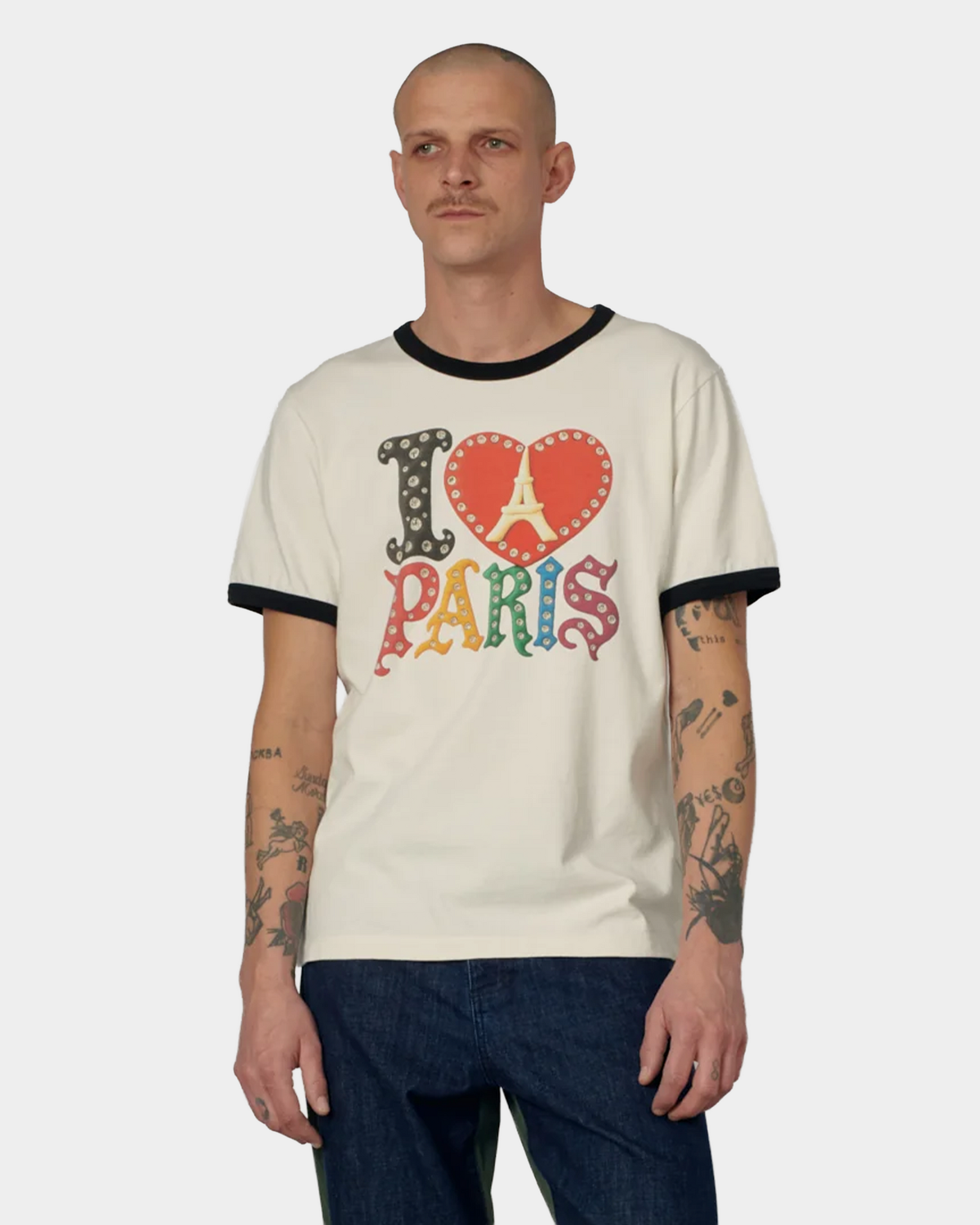 A man wearing the off white Rassvet Jewel Ringer T-Shirt with dark blue jeans, black ringer collar and cuffs visible