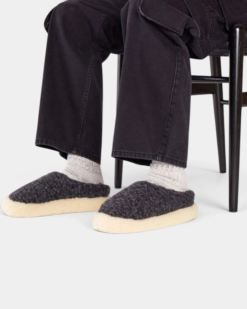 Rue De Wool The Nordic V2 slippers in charcoal black and natural, worn with light socks and black trousers